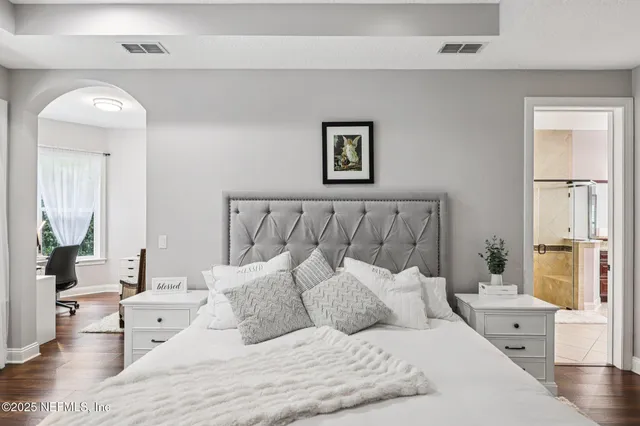 a bedroom with a bed and a chandelier