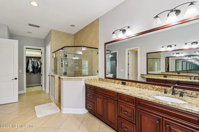 a bathroom with a granite countertop sink and a mirror