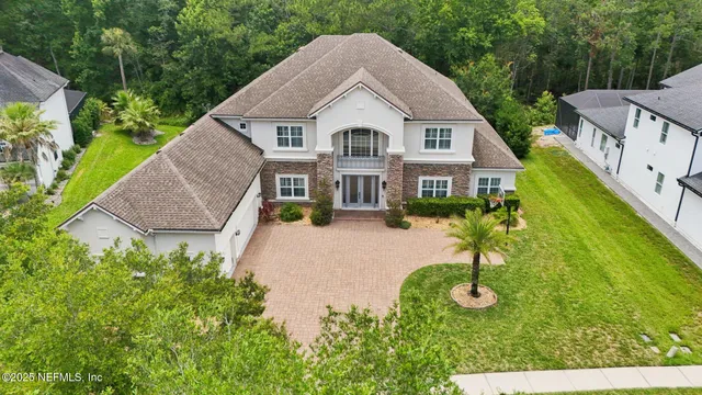 a view of house with garden and tall tress