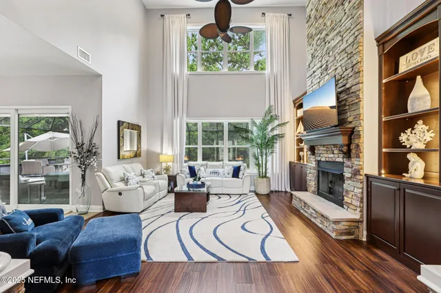 a living room with furniture a fireplace and a floor to ceiling window