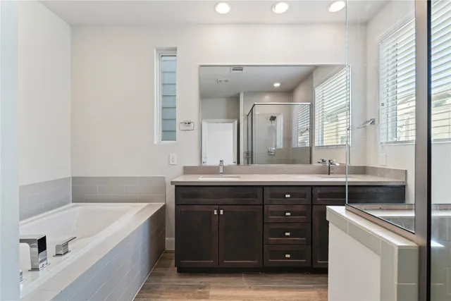 a spacious bathroom with a granite countertop sink mirror and bathtub