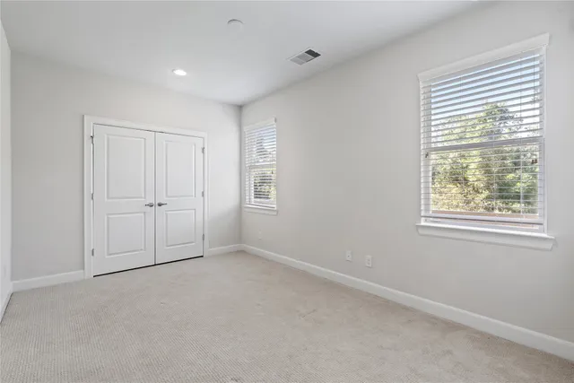 an empty room with windows and closet