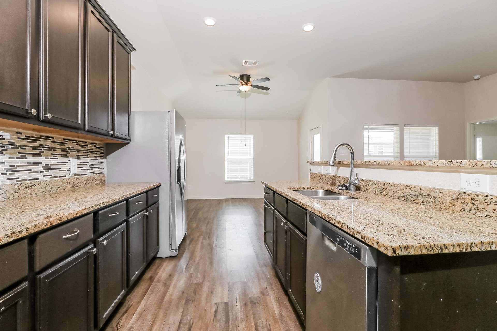 20017 Hubert R Humphrey Road Manor, TX 78653 - Photo 8 of 27 A well-appointed kitchen features rich cabinetry and gleaming countertops, extending to an open-concept living area.