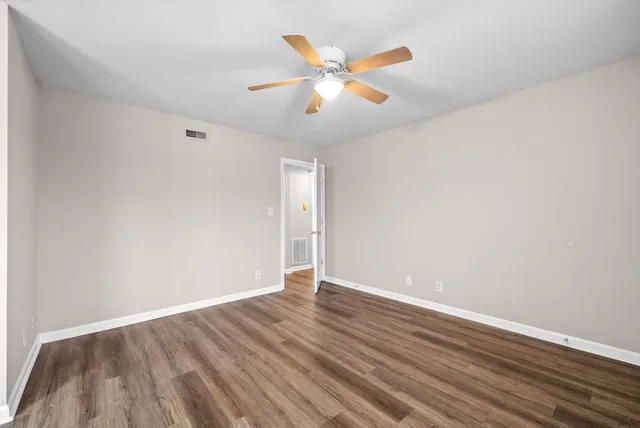 a view of an empty room with wooden floor