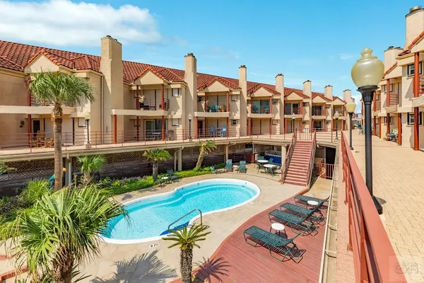 a front view of a house with swimming pool garden and patio