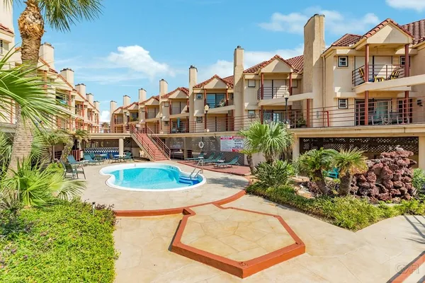 a front view of a house with a yard and potted plants