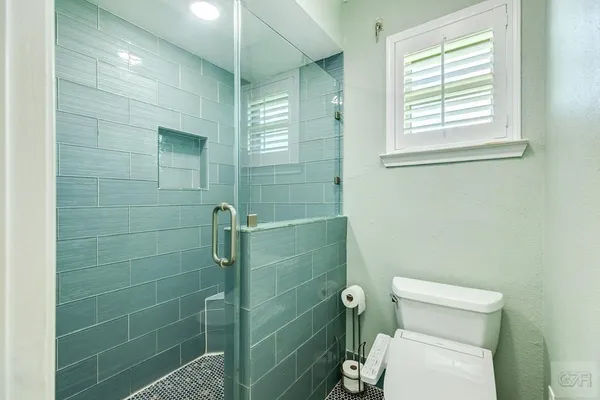 a bathroom with a toilet and a shower