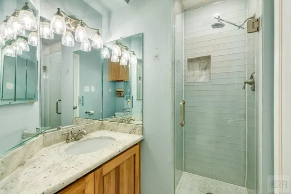 a bathroom with a granite countertop sink and a mirror
