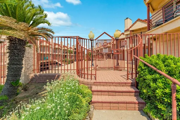 a view of a brick house with a flower garden