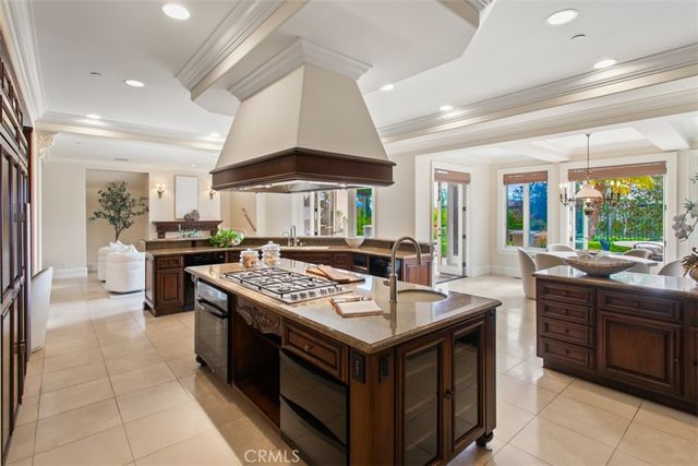 a kitchen with stainless steel appliances granite countertop a table chairs and a refrigerator