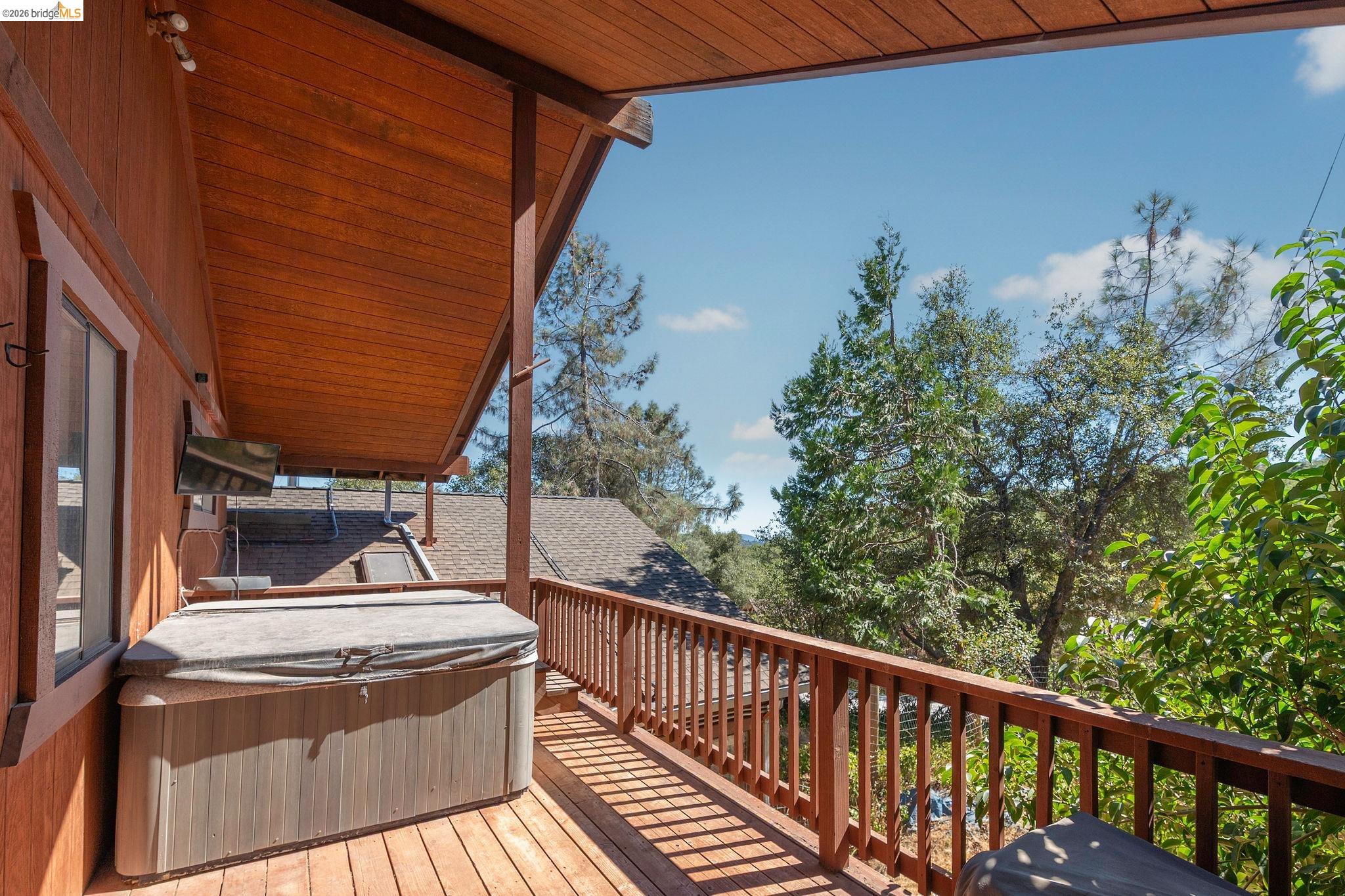 22963 Robertson Ranch Road Sonora, CA 95370 - Photo 31 of 90 Expansive wood-finish deck featuring a spa, wood railing, and a slatted wood ceiling