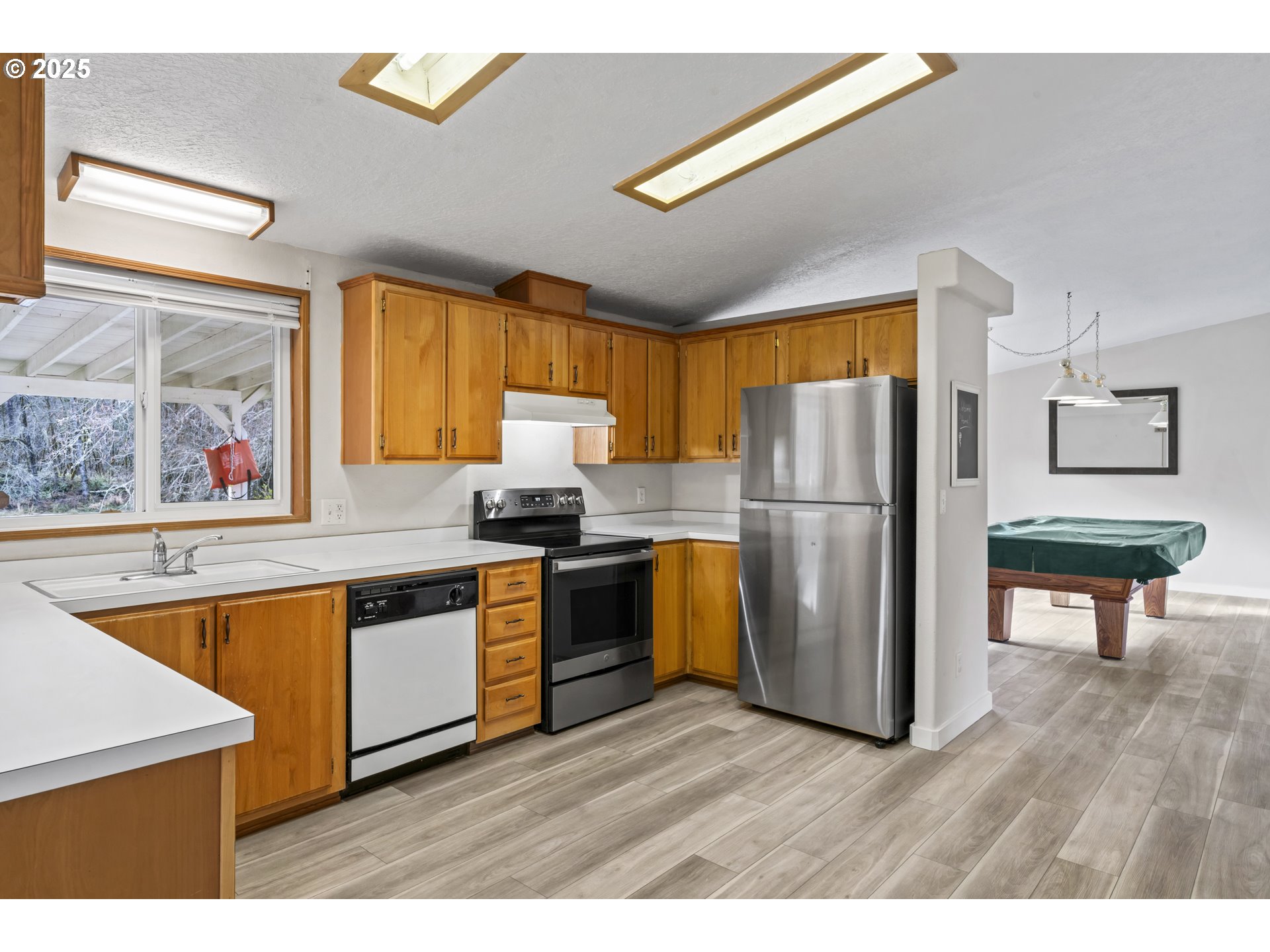 47520 Perkins Street Oakridge, OR 97463 - Photo 19 of 44 a kitchen with stainless steel appliances granite countertop a refrigerator a sink dishwasher a stove and white countertops with wooden floor