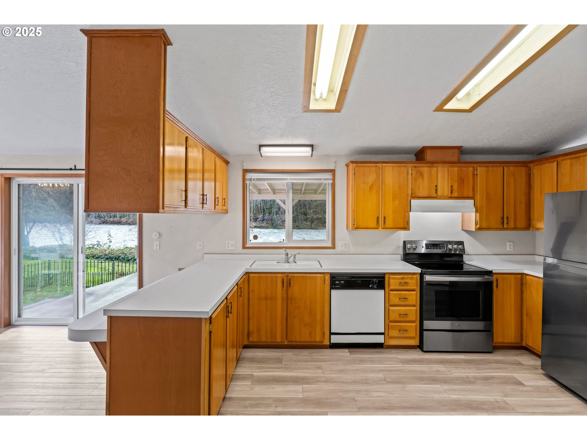 47520 Perkins Street Oakridge, OR 97463 - Photo 20 of 44 a kitchen with stainless steel appliances granite countertop a stove a sink and a refrigerator