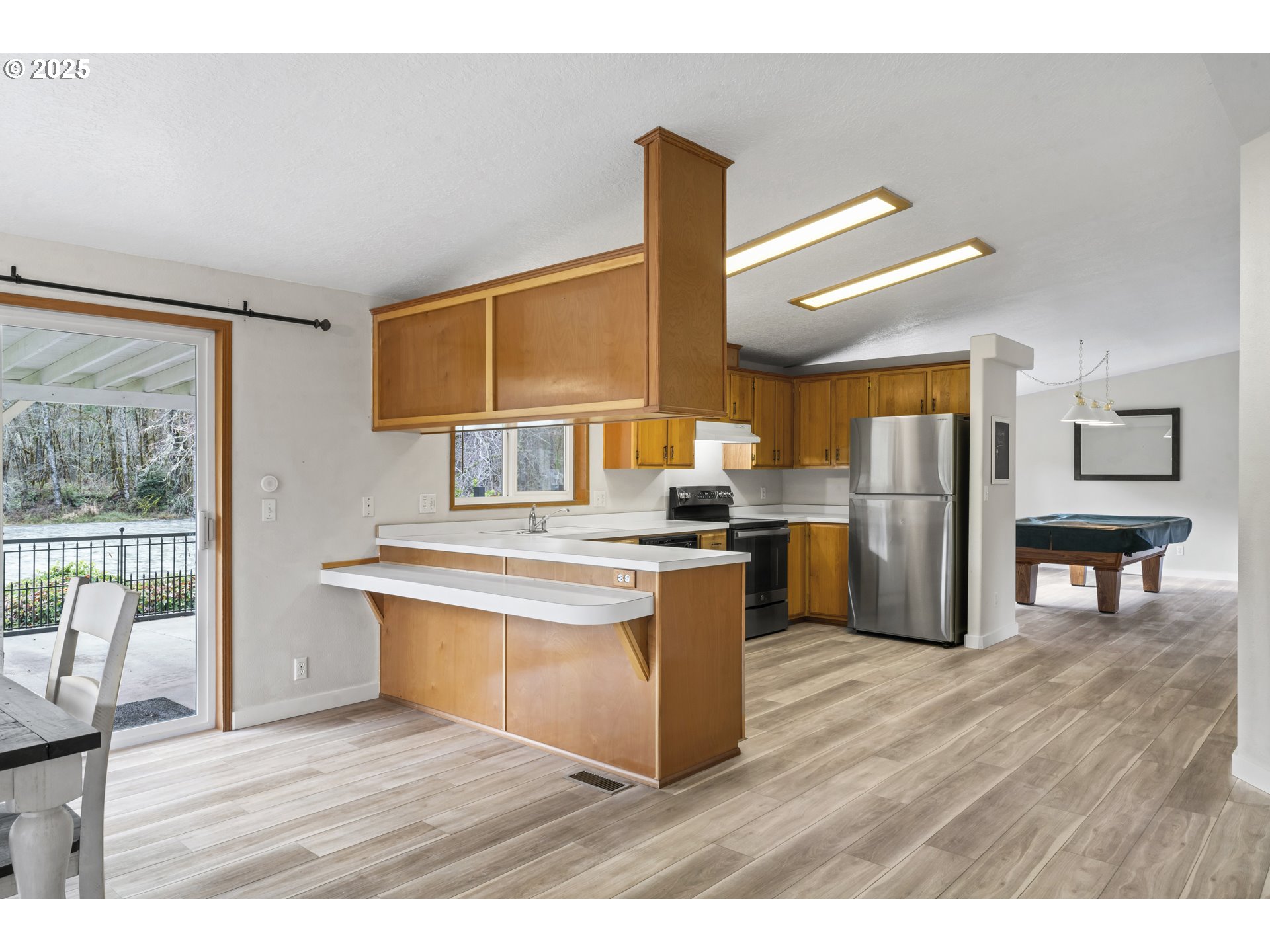 47520 Perkins Street Oakridge, OR 97463 - Photo 23 of 44 a kitchen with stainless steel appliances wooden floor and large windows