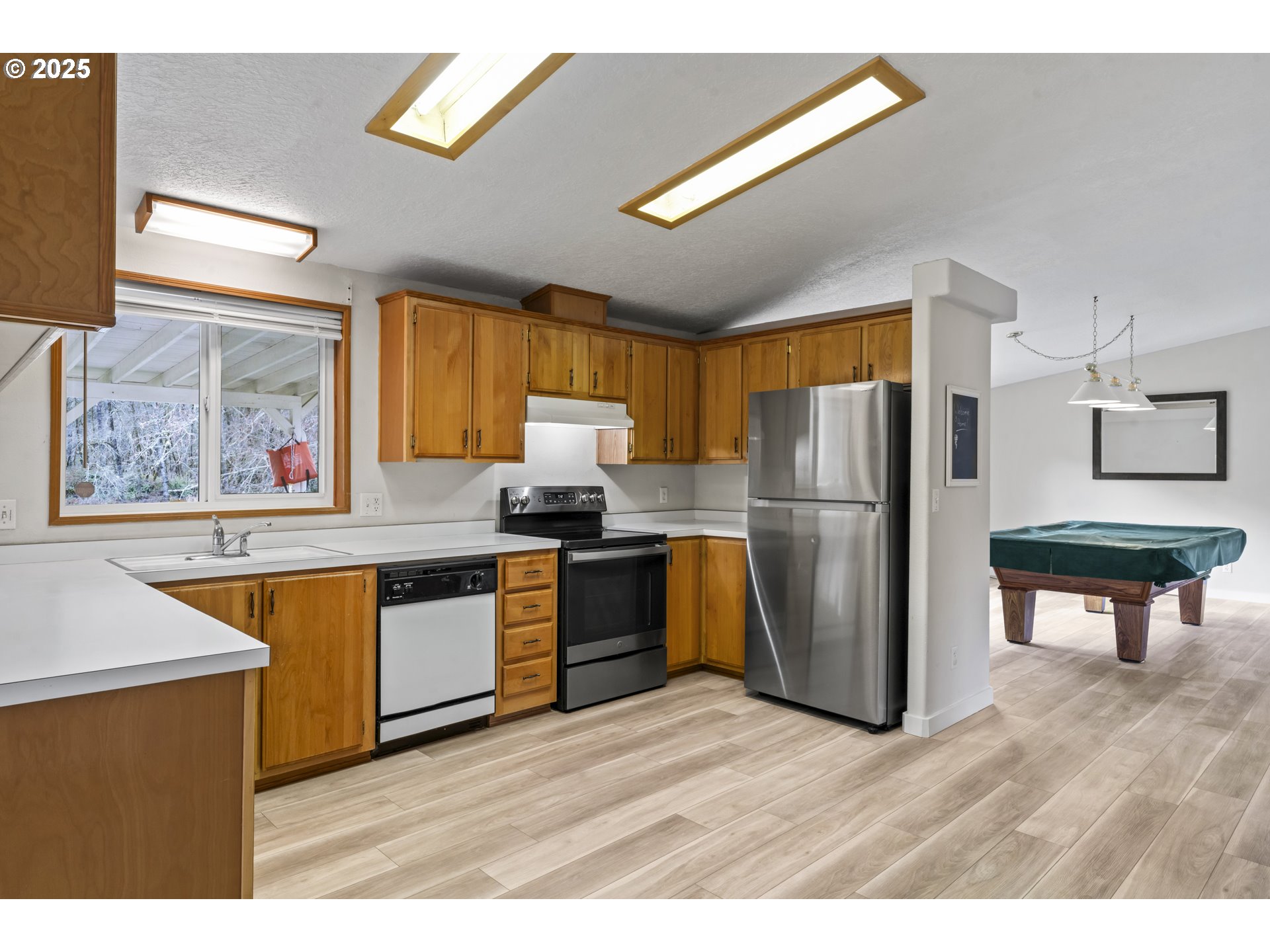 47520 Perkins Street Oakridge, OR 97463 - Photo 25 of 44 a kitchen with stainless steel appliances granite countertop a refrigerator a sink dishwasher a stove with wooden floor and cabinets
