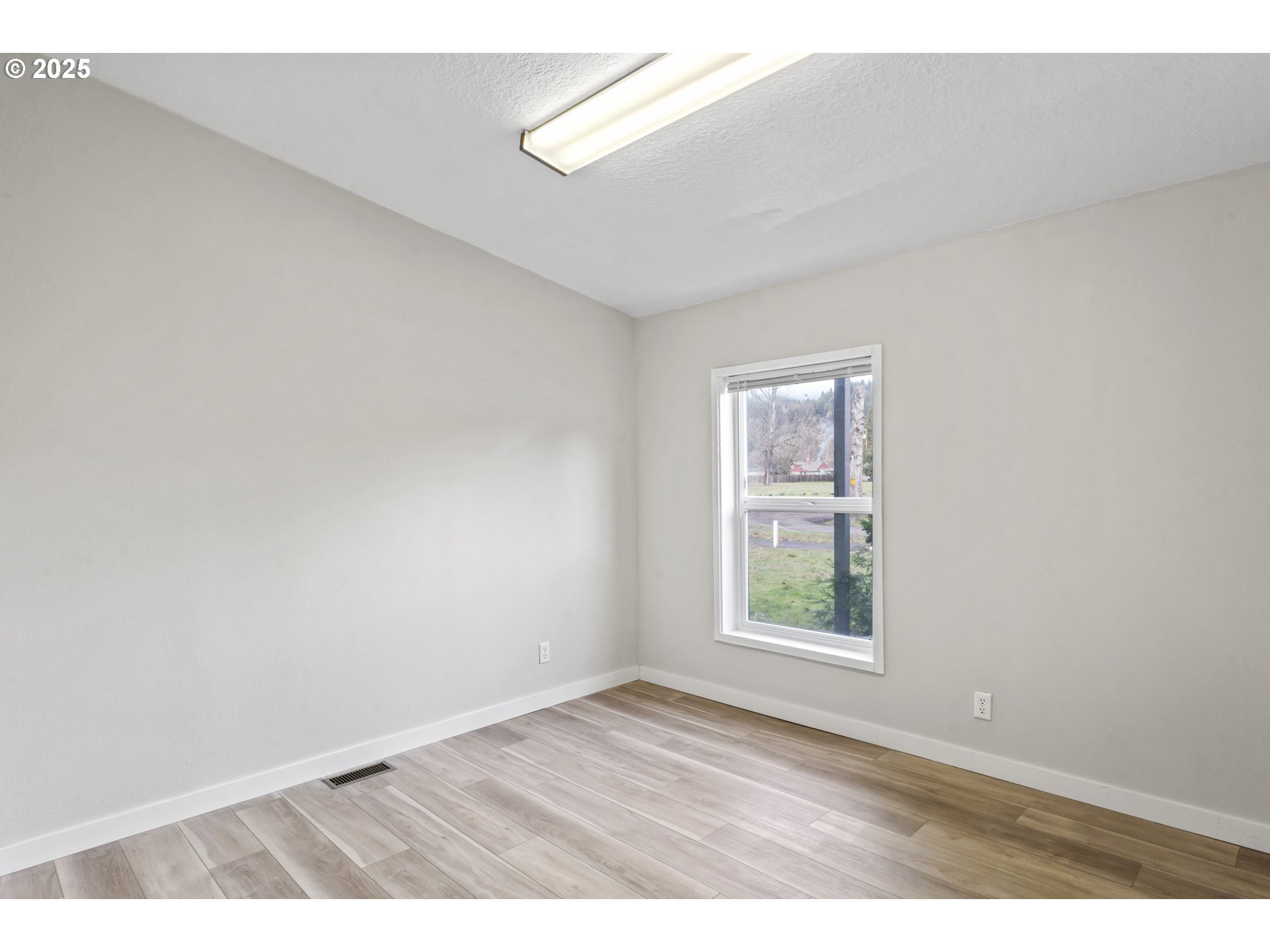 47520 Perkins Street Oakridge, OR 97463 - Photo 26 of 44 an empty room with wooden floor and windows