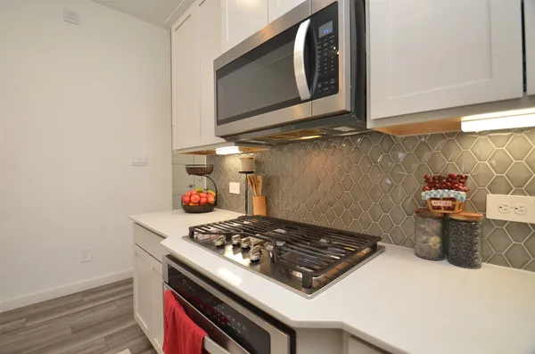 a stove top oven sitting inside of a kitchen