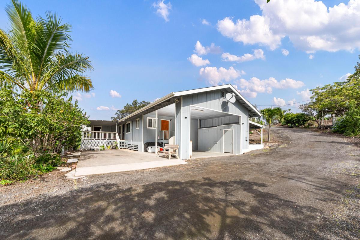 92-8583 Paradise Parkway Ocean View, HI 96704 - Photo 1 of 28 a front view of a house with a yard and potted plants