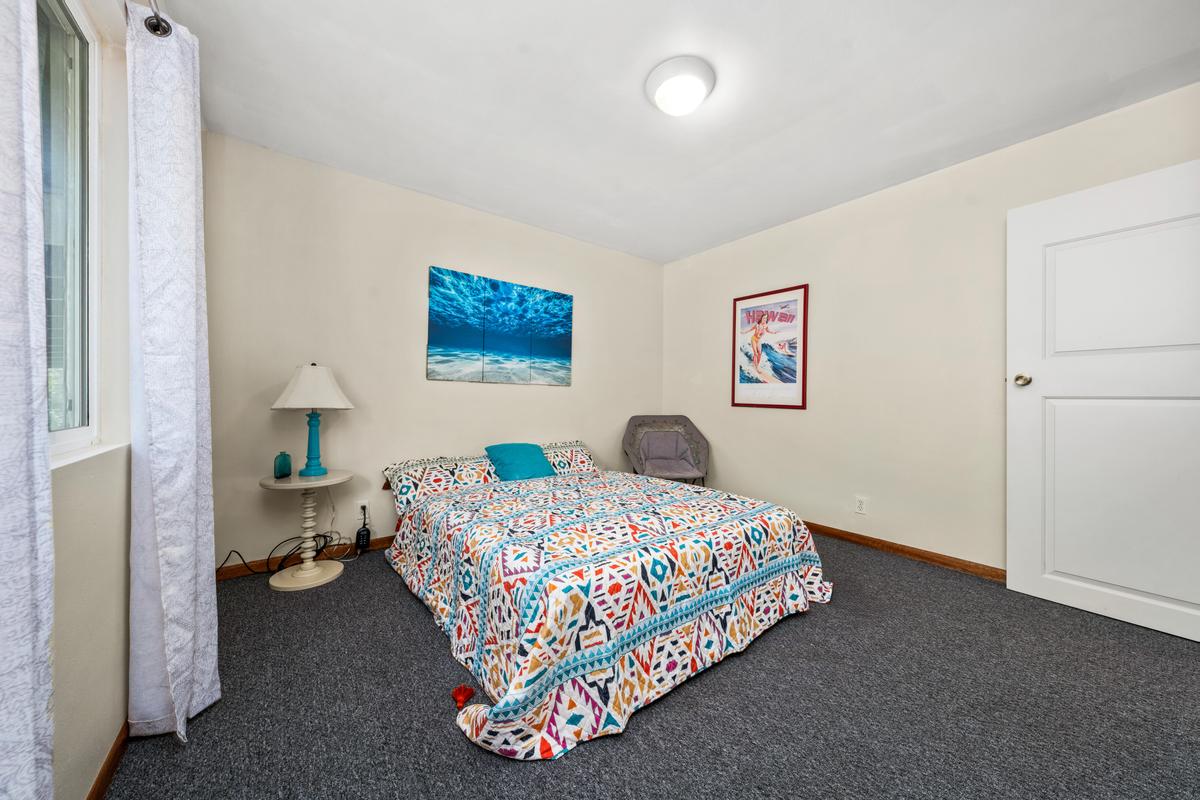 92-8583 Paradise Parkway Ocean View, HI 96704 - Photo 12 of 28 a bedroom with a bed and a painting on the wall