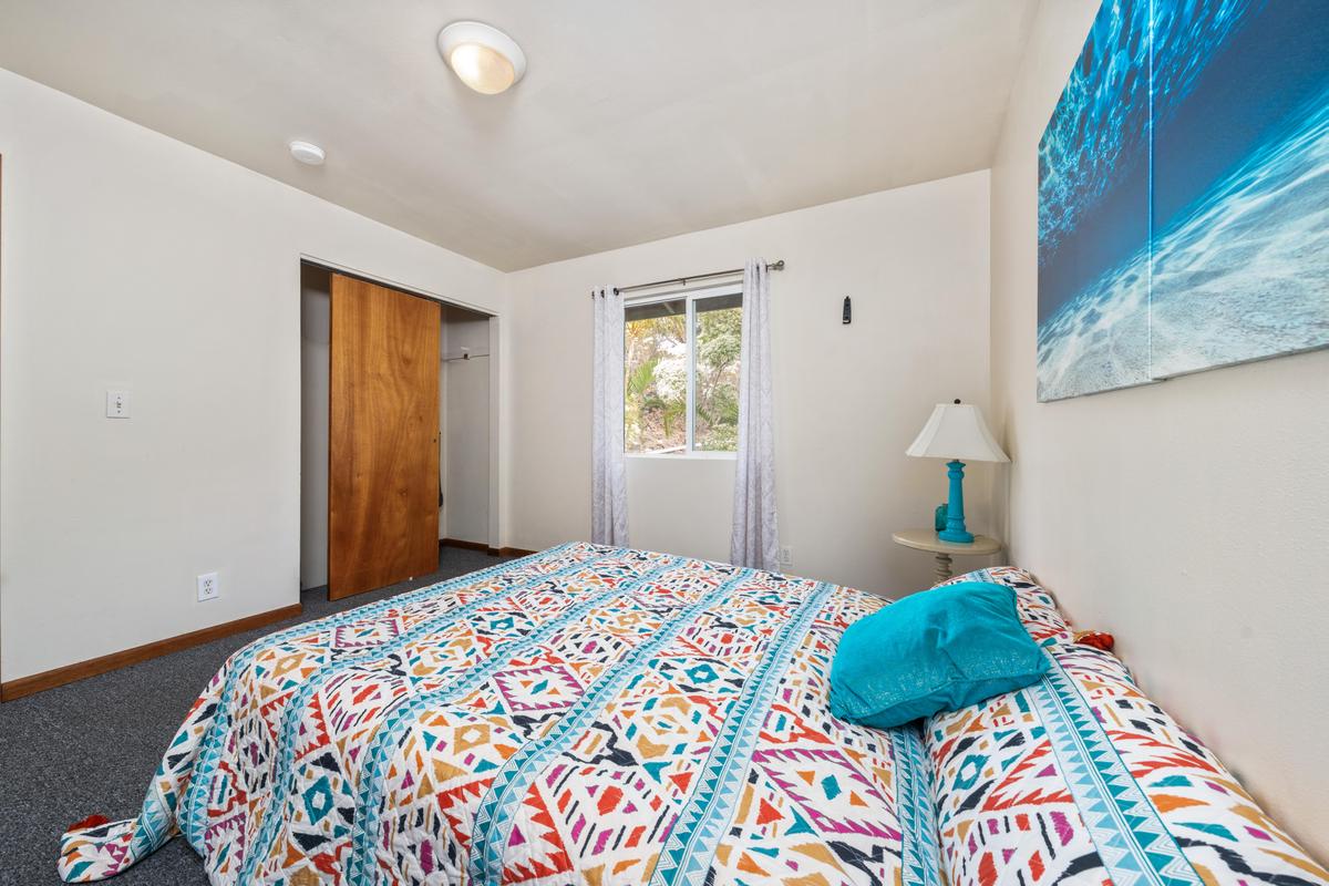92-8583 Paradise Parkway Ocean View, HI 96704 - Photo 13 of 28 a bedroom with a bed and a window