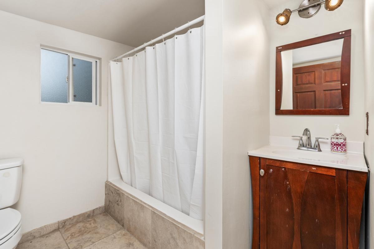 92-8583 Paradise Parkway Ocean View, HI 96704 - Photo 16 of 28 a bathroom with a sink a toilet and mirror