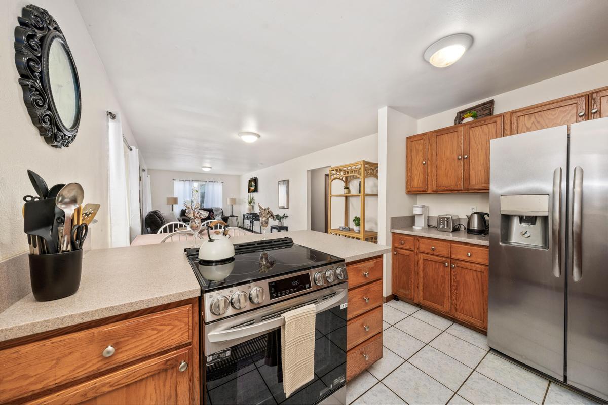 92-8583 Paradise Parkway Ocean View, HI 96704 - Photo 4 of 28 a kitchen with stainless steel appliances granite countertop a sink a stove and a refrigerator