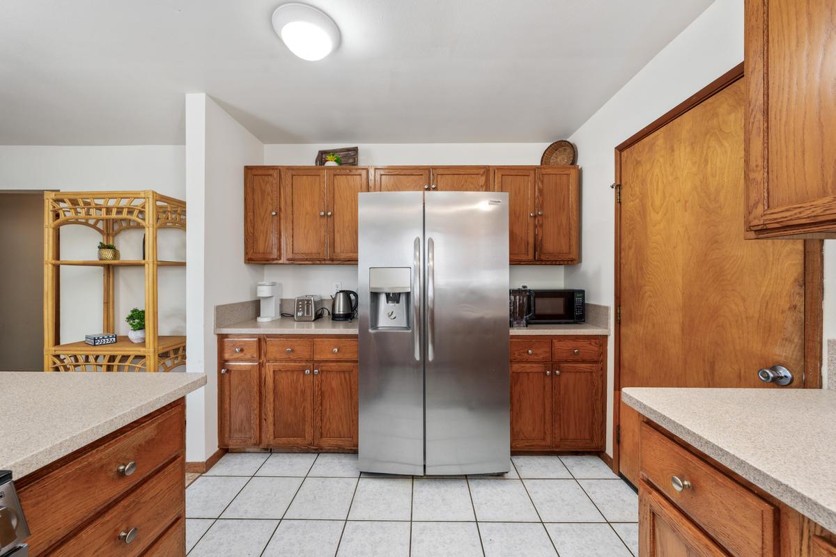 92-8583 Paradise Parkway Ocean View, HI 96704 - Photo 5 of 28 a kitchen with stainless steel appliances granite countertop a refrigerator and a sink