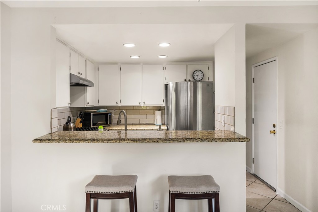 5573 East Vista Del Rio Anaheim, CA 92807 - Photo 13 of 42 a kitchen with stainless steel appliances granite countertop a sink refrigerator and microwave