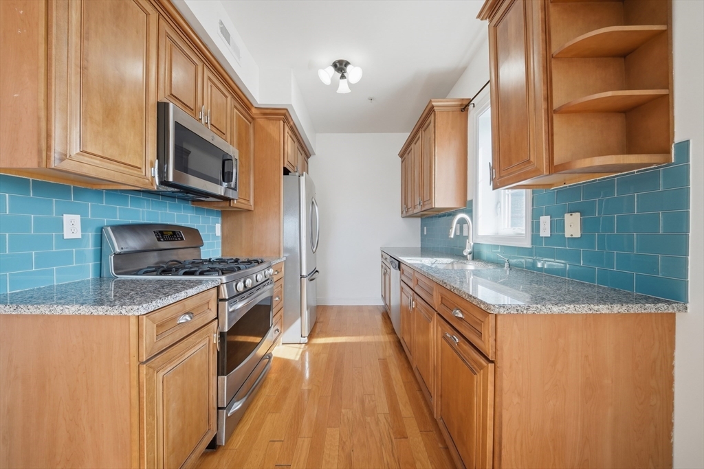 233 Beach Road, Unit A11 Salisbury, MA 01952 - Photo 7 of 37 a kitchen with stainless steel appliances granite countertop a stove a sink and a refrigerator