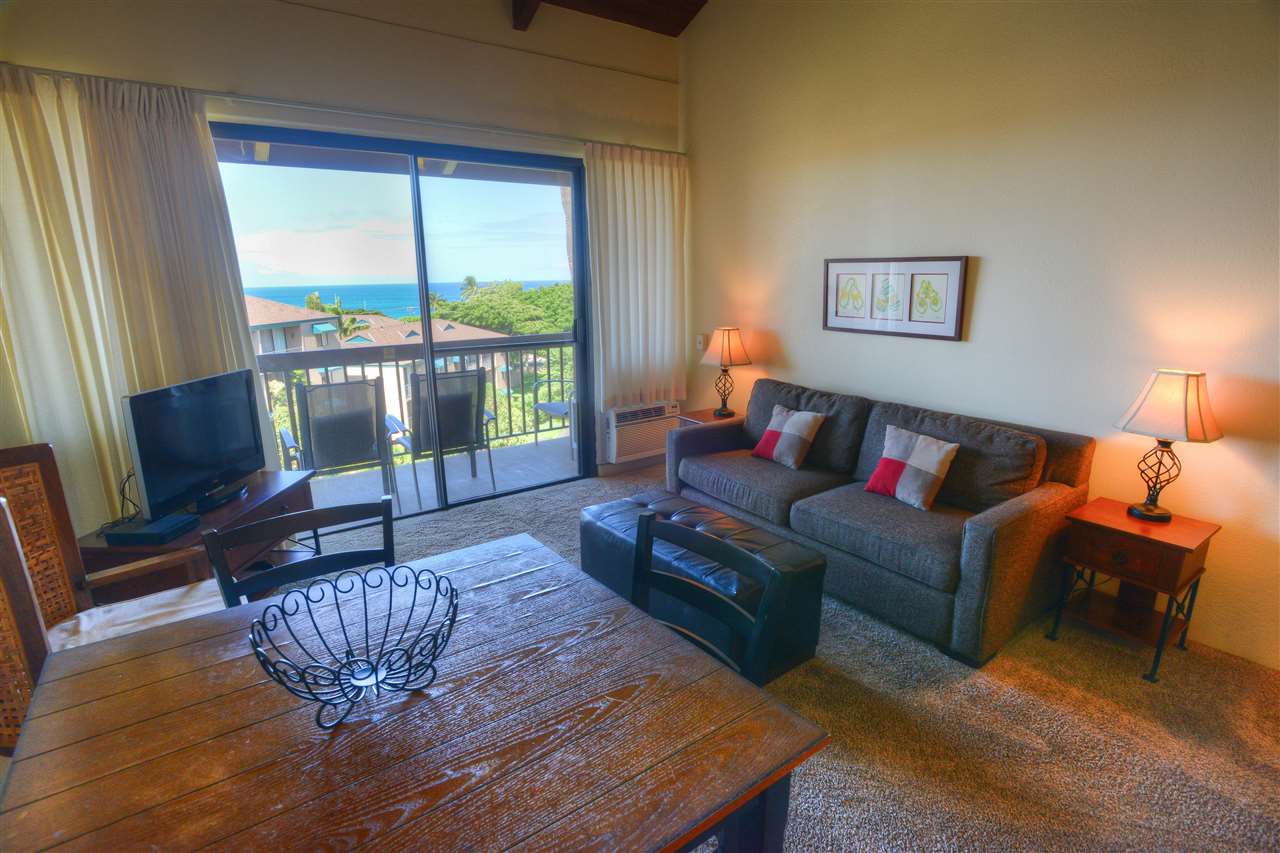 a living room with furniture a flat screen tv and a large window
