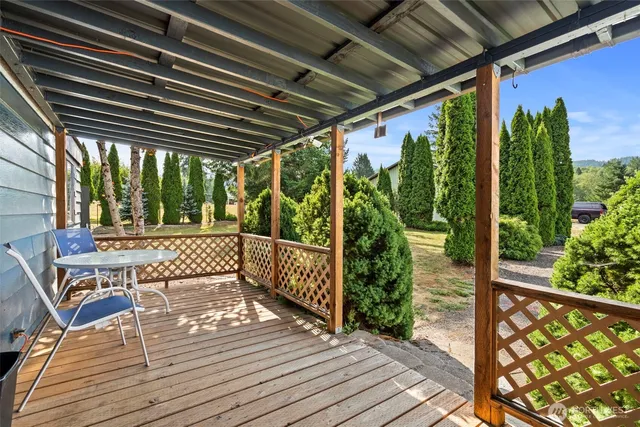 a living room with furniture a flat screen tv and kitchen view