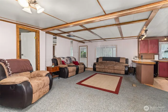 a kitchen with stainless steel appliances kitchen island granite countertop a sink dishwasher and a dining table with chairs