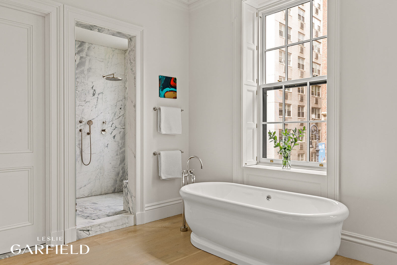 60 West 9th Street Manhattan, NY 10011 - Photo 12 of 22 a bathroom with a white bath tub a shower and a window