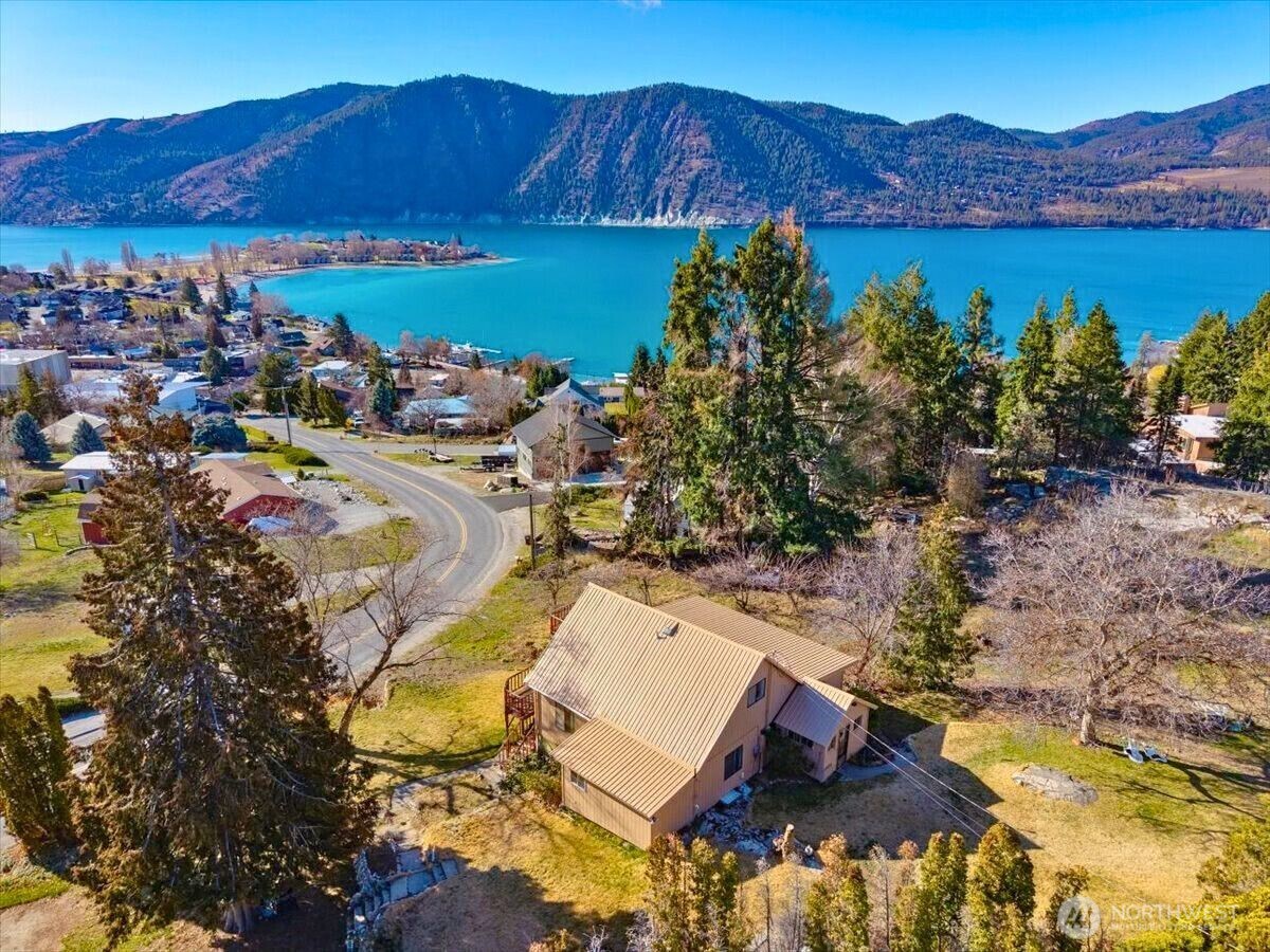 an aerial view of a house with garden space and mountains