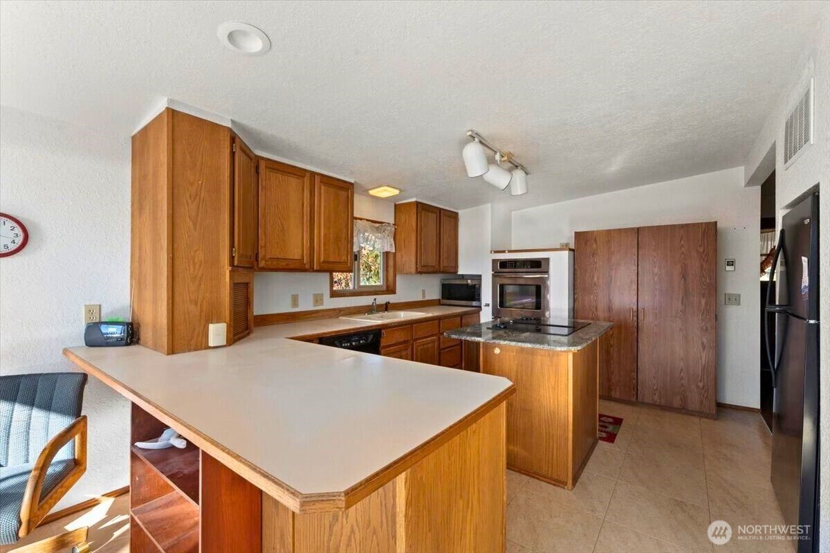 475 Totem Pole Road Manson, WA 98831 - Photo 6 of 33 a kitchen with stainless steel appliances a stove refrigerator sink and microwave