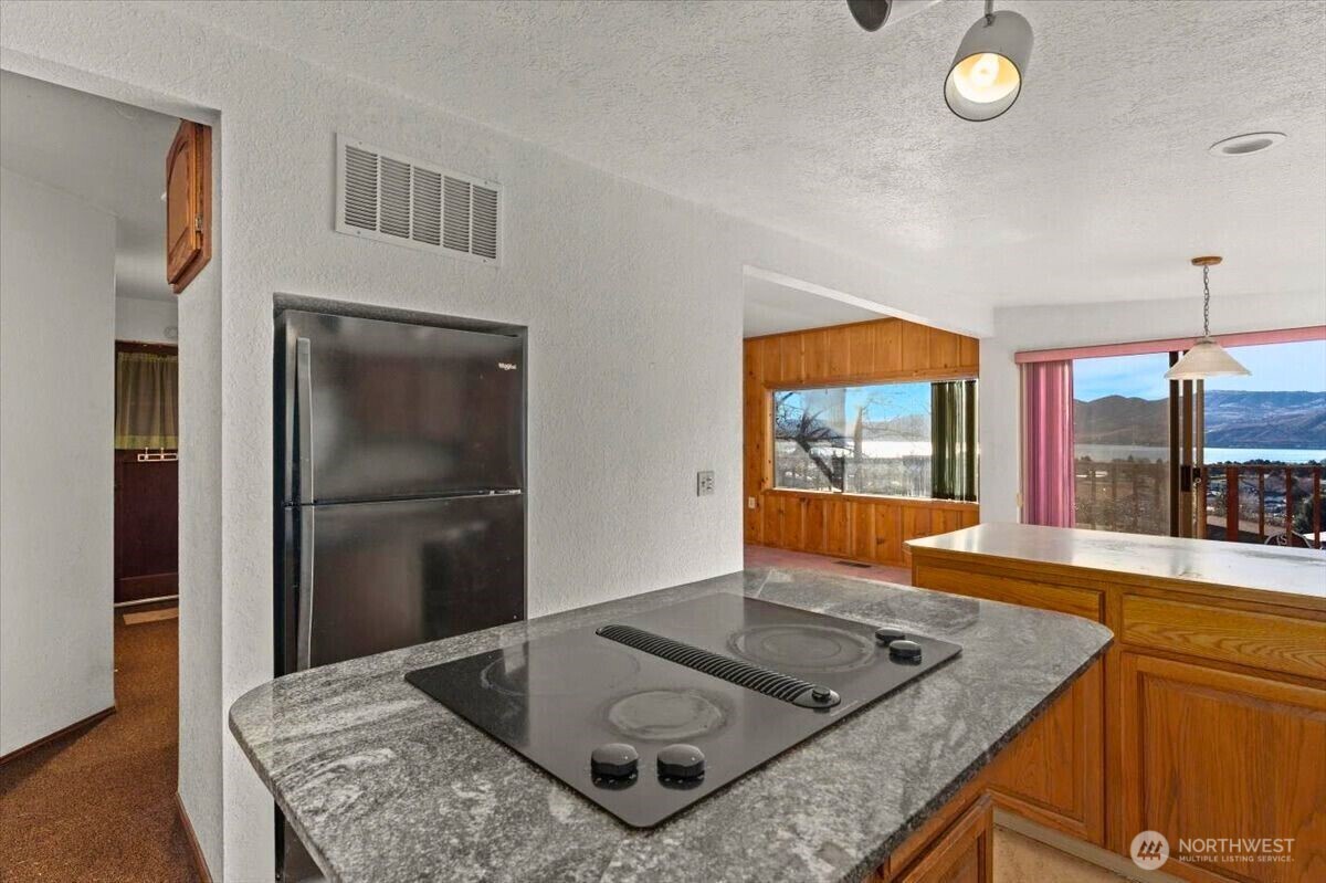 475 Totem Pole Road Manson, WA 98831 - Photo 7 of 33 a kitchen with stainless steel appliances granite countertop a sink and a refrigerator
