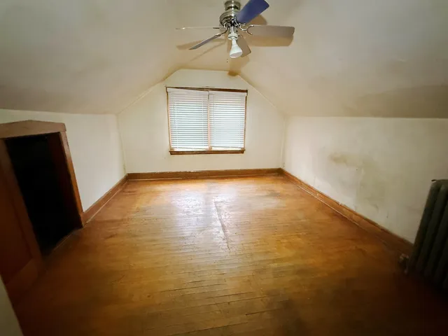 an empty room with windows and fireplace