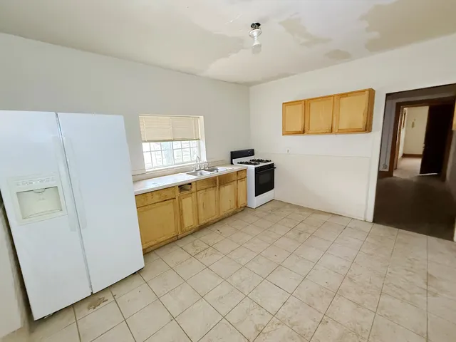 a view of a kitchen with microwave and refrigerator