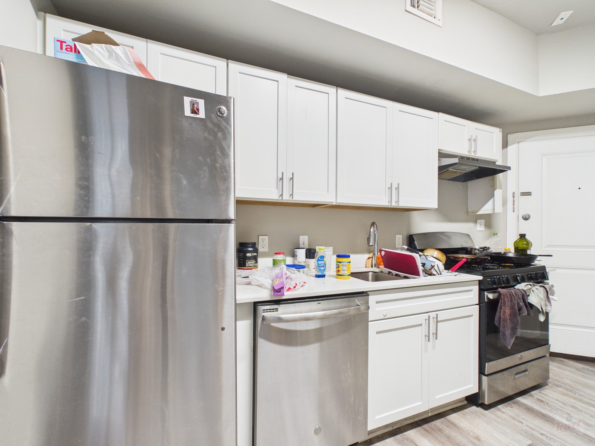 911 West 22nd Street, Unit 404 Austin, TX 78705 - Photo 2 of 13 a kitchen with a white cabinets and white appliances