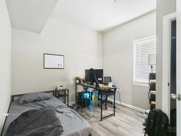 a bedroom with a bed and a computer on a desk