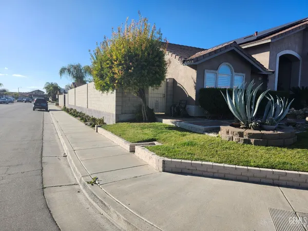 a view of a house with backyard and a tree
