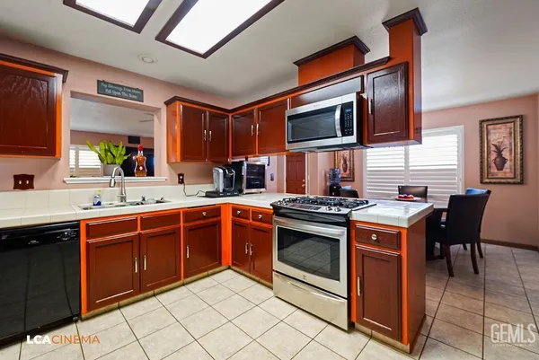 a kitchen with stainless steel appliances granite countertop a stove top oven a sink dishwasher and cabinets