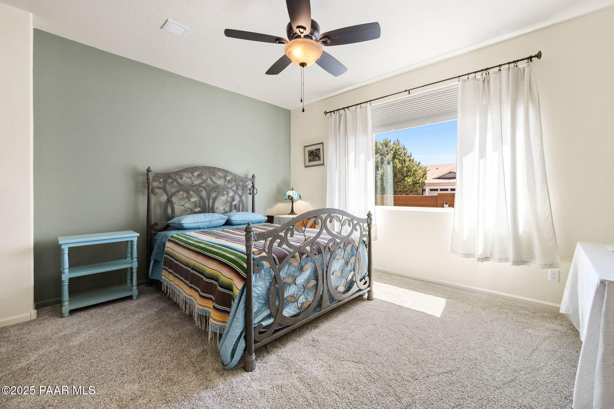 7794 Lavender Loop Prescott Valley, AZ 86315 - Photo 16 of 57 a bedroom with a bed table and a chandelier