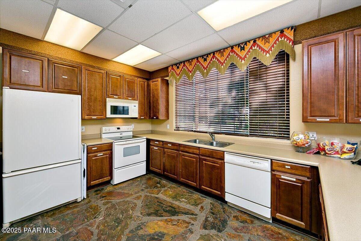 7794 Lavender Loop Prescott Valley, AZ 86315 - Photo 49 of 57 a kitchen with a stove a sink and a refrigerator