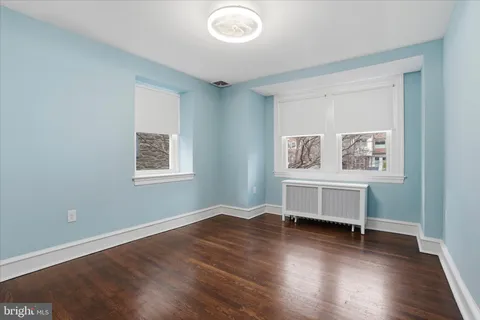a view of a bedroom with wooden floor and window