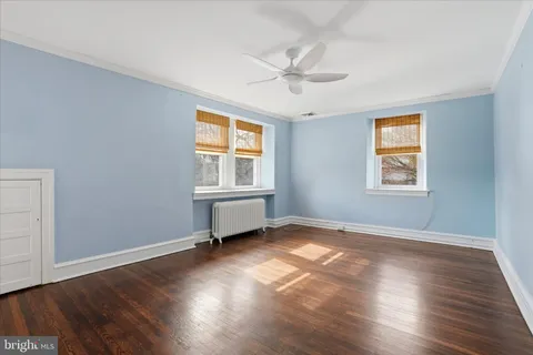 a view of a big room with wooden floor and windows