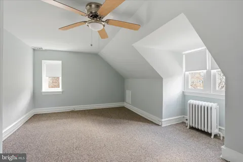 an empty room with a window and a ceiling fan