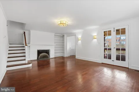a view of a livingroom with wooden floor and a fireplace