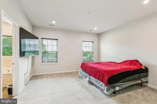 a spacious bedroom with a bed and a window