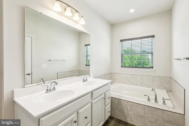 a bathroom with a bathtub a sink and a window